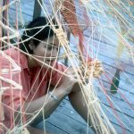 Photo of a dark-haired woman with a net in front of her