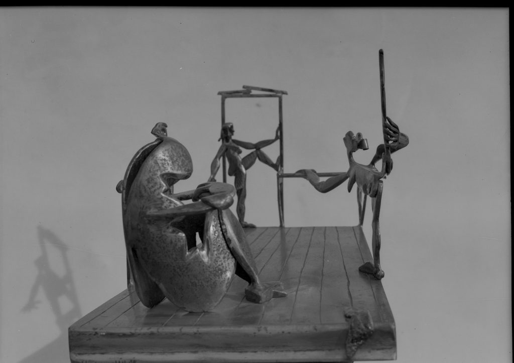 black and white photograph of a bronze sculpture featuring dancers warming up in a studio