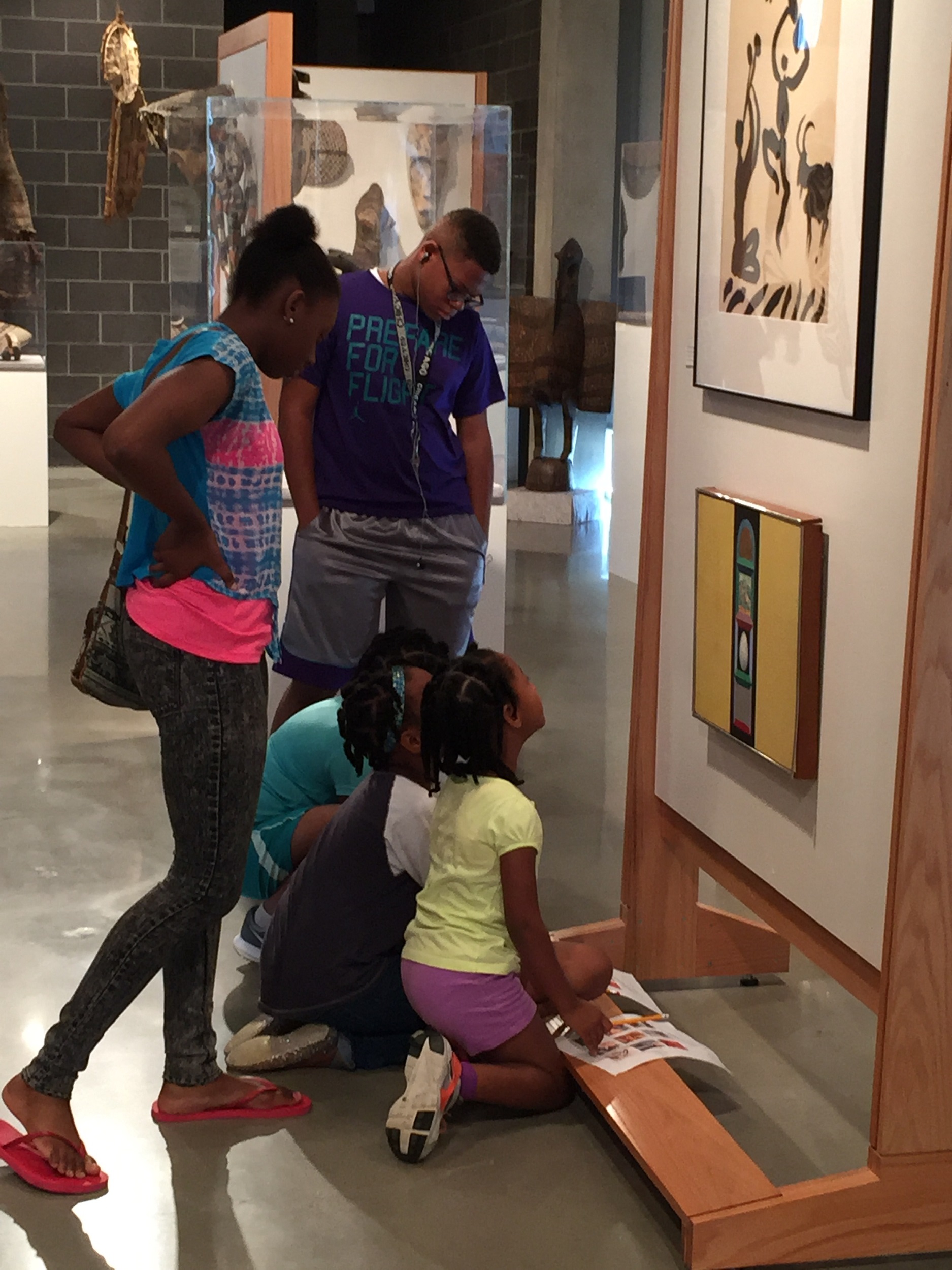 Photograph of five Black students looking at artwork in a gallery