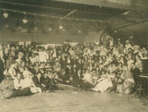 Black-and-white photograph of a party with people in costume. Several are in blackface.