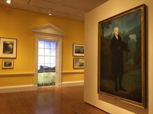 Color photograph of interior of museum gallery with a large portrait of Thomas Jefferson on the right