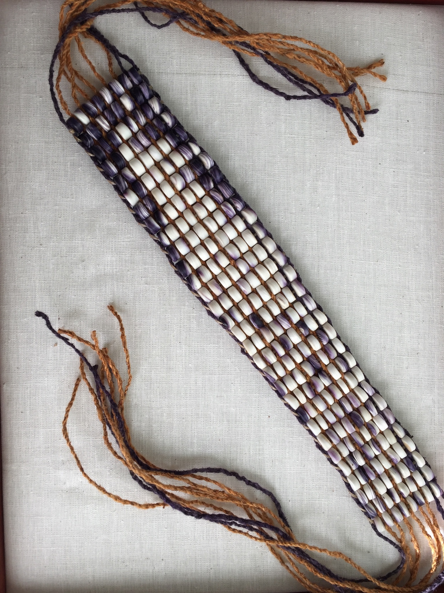 Color photograph of a beaded wampum belt with tasseled ties