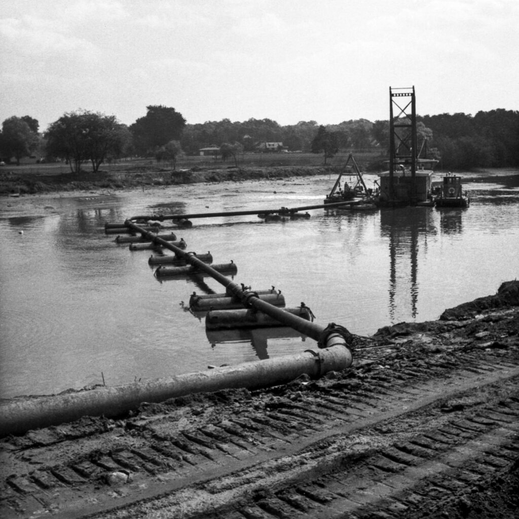 Black and white photograph of an industrial riverscape