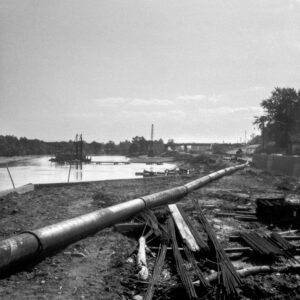 Black-and-white photograph of an industrial riverscape