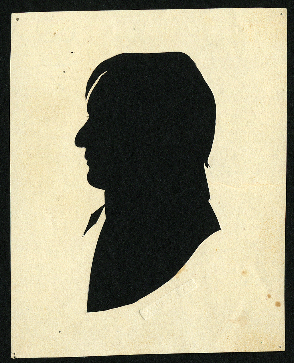 Black-and-white cut-paper silhouette of a man facing left, with details suggesting a collar and tie
