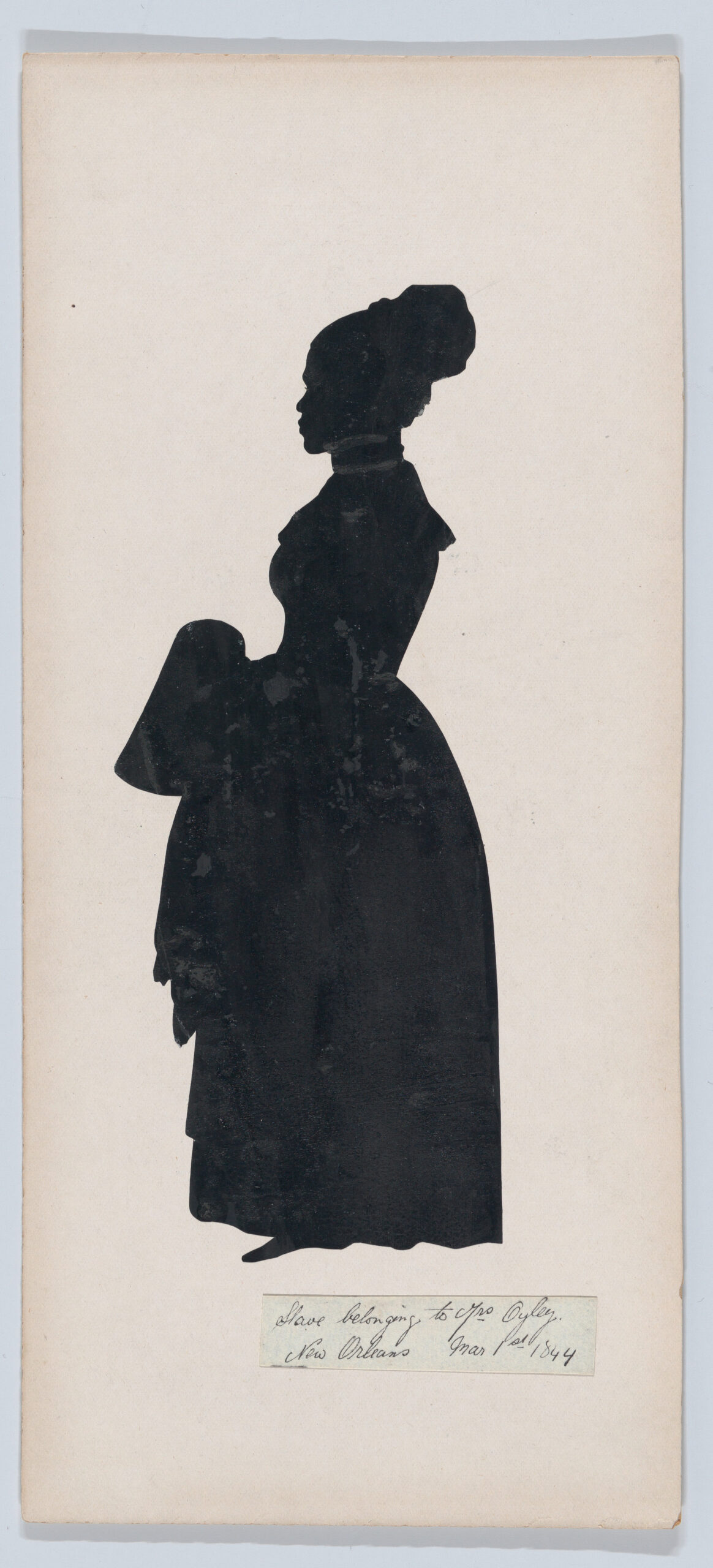 Full-length cut-paper silhouette of a woman in a long dress, with her hair tied up on top of her head, in black and white with white detailing