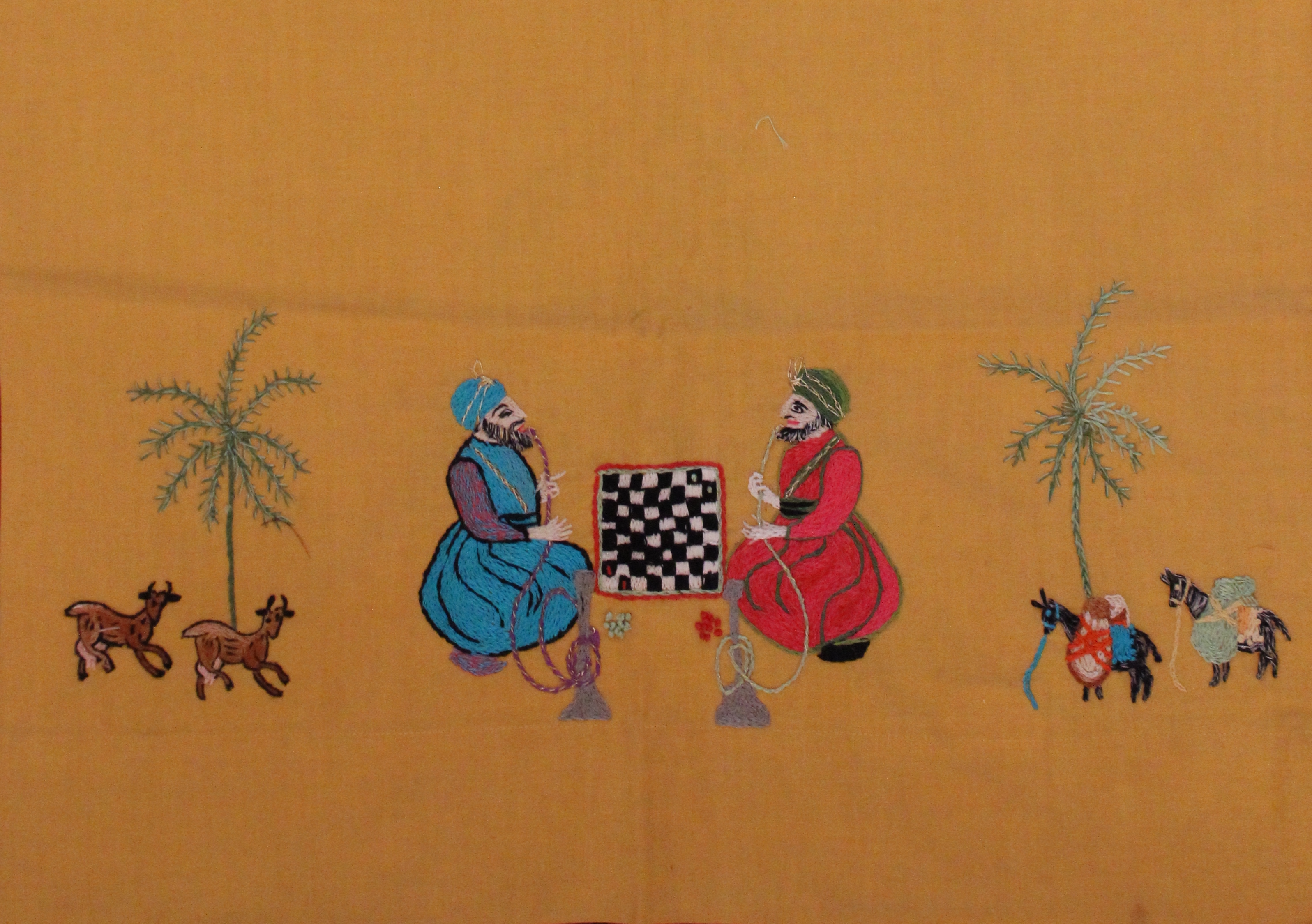 Embroidered scene of two men with hookah pipes seated on the ground across from a checkerboard 