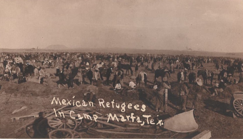 Historical black-and-white photo of a refugee camp with the following words printed on it in white: "Mexican Refugees / In Camp Marfa, Tex."