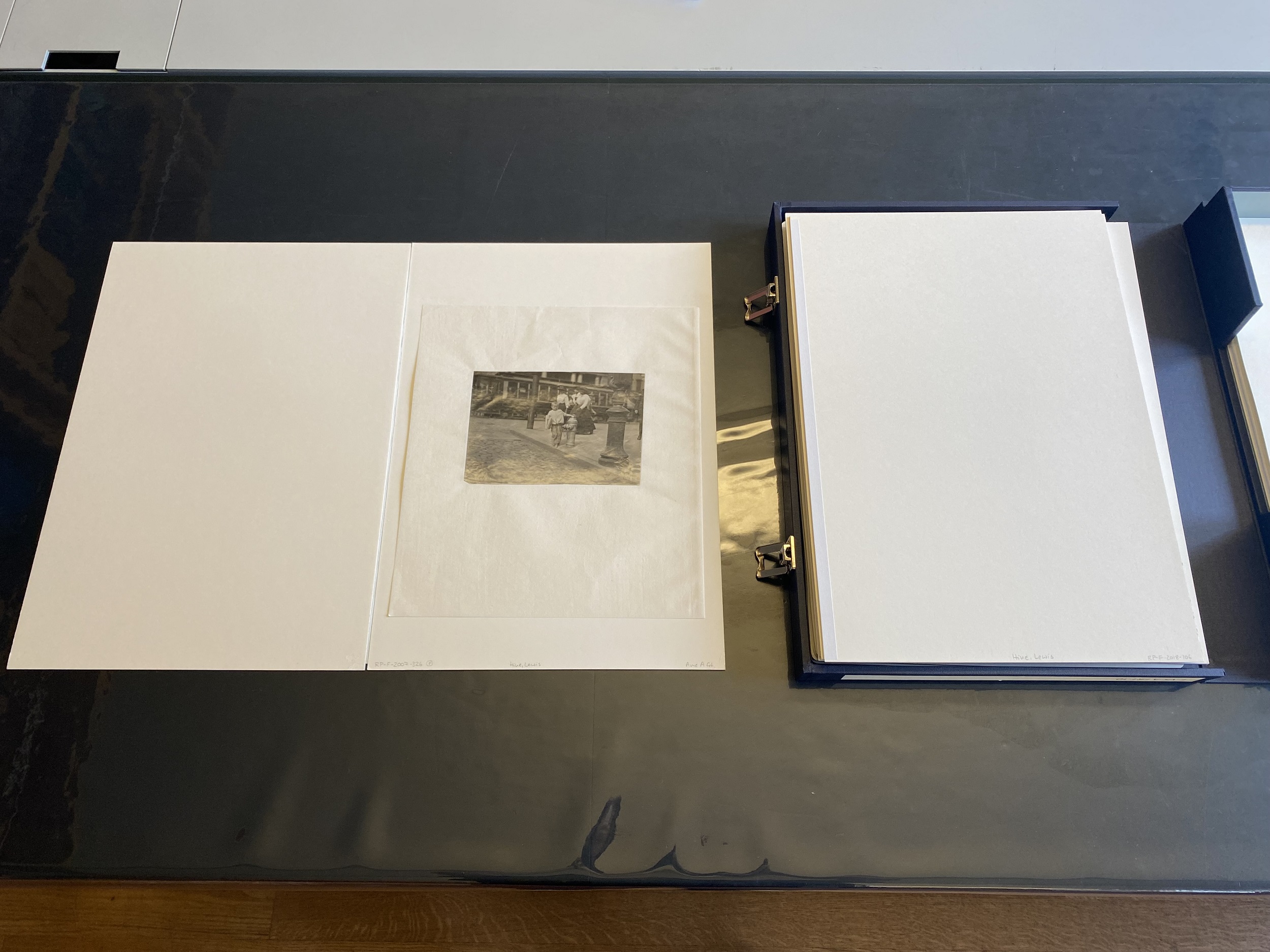 Photograph of an open archival storage box, with the photograph in figure 2 on the left.