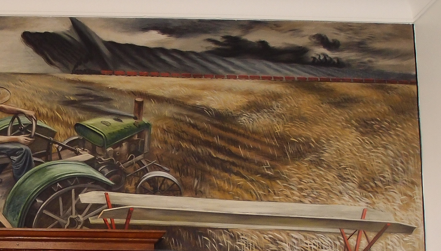Detail of the mural in fig. 1, showing the green tractor to the left and the approaching clouds to the right.