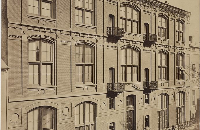 Black-and-white historic photograph of building with large, arched windows