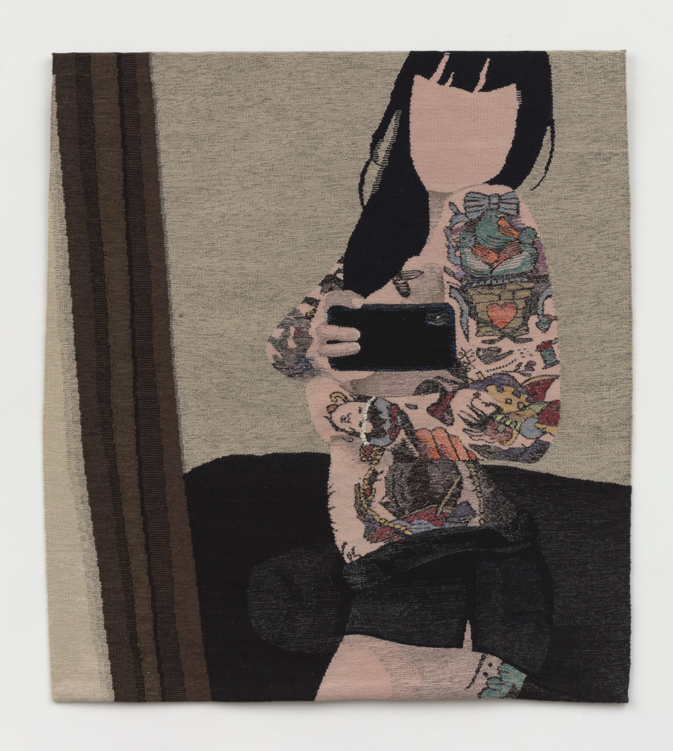 Woven tapestry showing a dark-haired woman with tattoos up and down her arms taking a picture of herself with a cell phone
