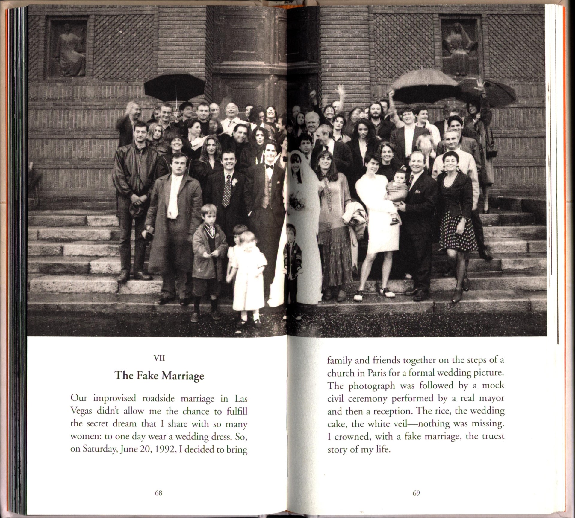 An open book with a black-and-white photo spread across two pages of a group of people standing on the steps of church, with a bride and groom in the center. Text beneath the photo has the header "VII / The Fake Marriage"