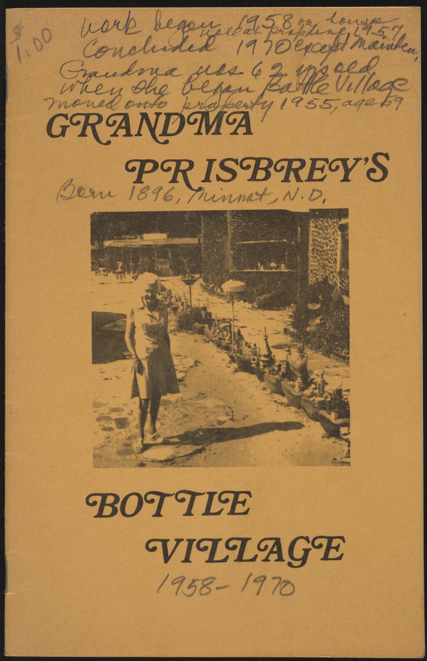 Front page of a brochure titled "Grandma Prisbrey's Bottle Village," with a black-and-white photograph of a woman standing in front of a structure created from glass bottles. Penciled in the upper left is "$1.00"; below the photo is penciled "1958–1970."