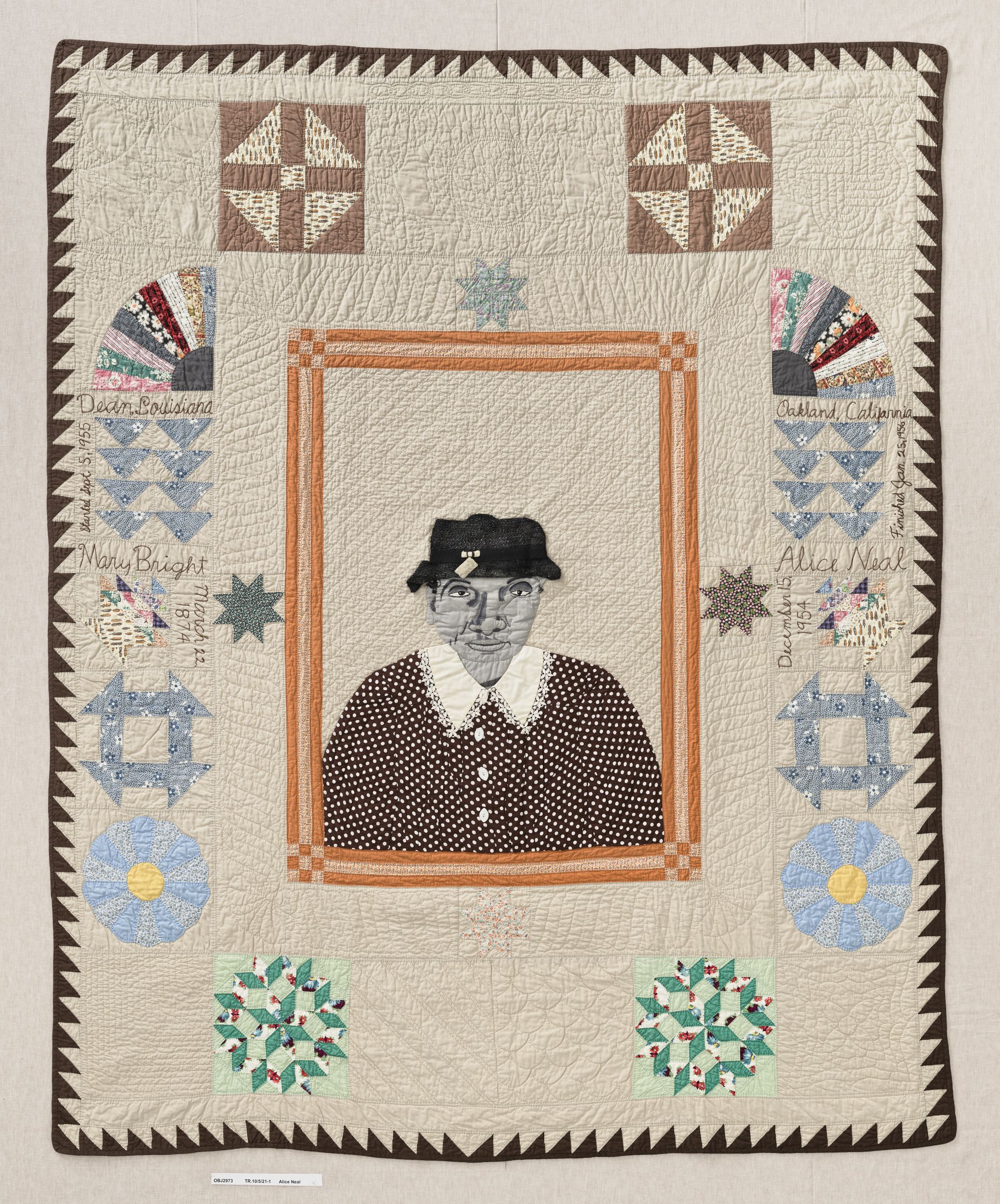 Quilt with image of a framed portrait in its center; the woman in the portrait wears a black hat and a black-and-white polka-dot dress with a white collar. There are handwritten inscriptions on either side. The quilt is elaborately stitched and edged with a brown sawtooth border.