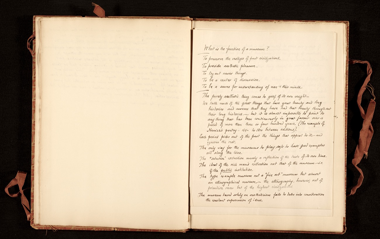 Open book with handwritten notes on the right-hand page, under the header "What is the purpose of a museum?"